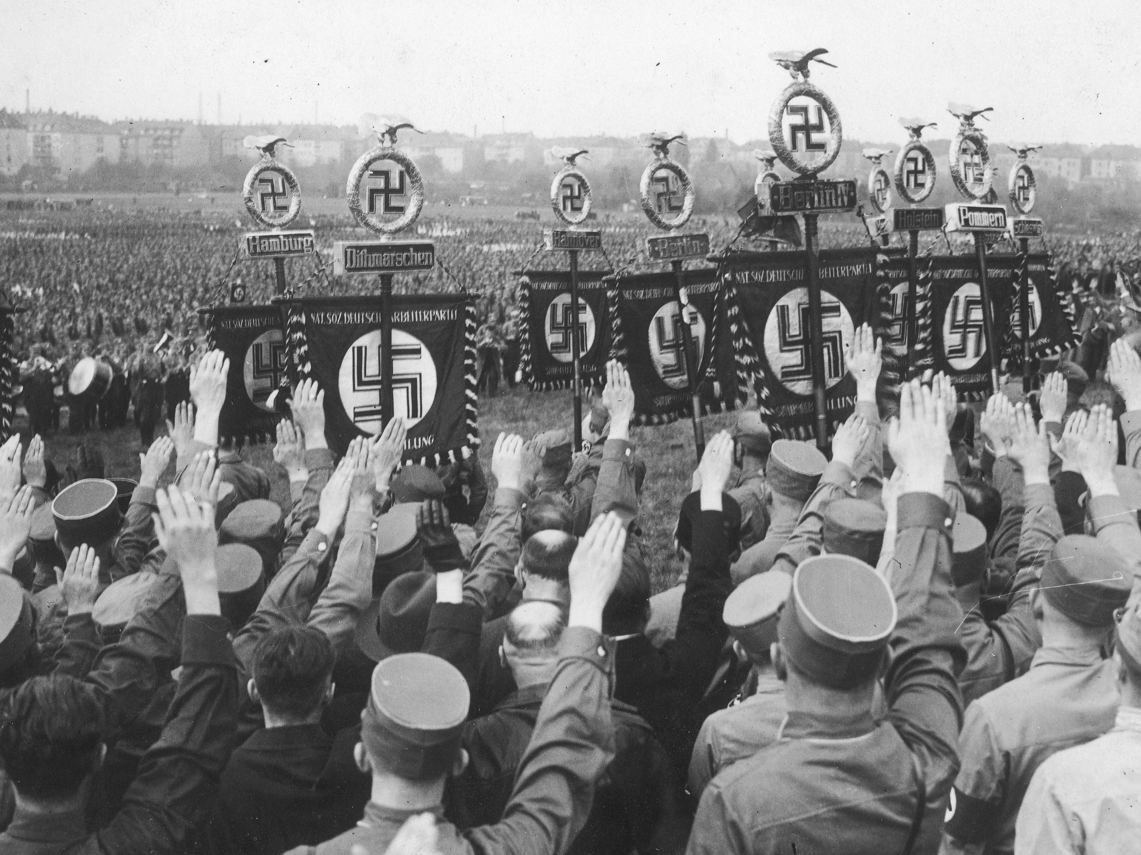 Członkowie NSDAP i SA wykonują salut rzymski