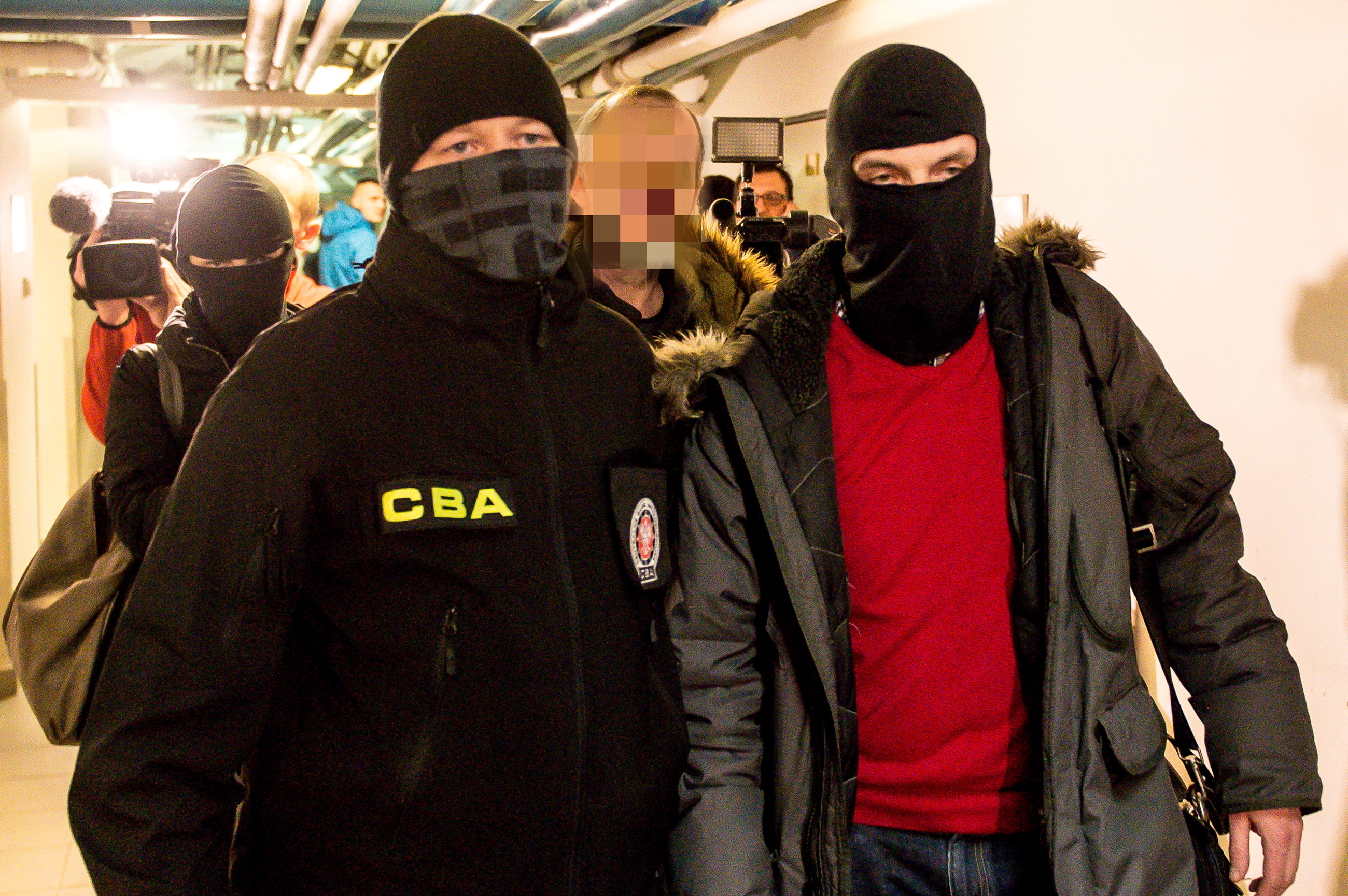 Agenci CBA prowadzą Jakuba R. na przesłuchanie