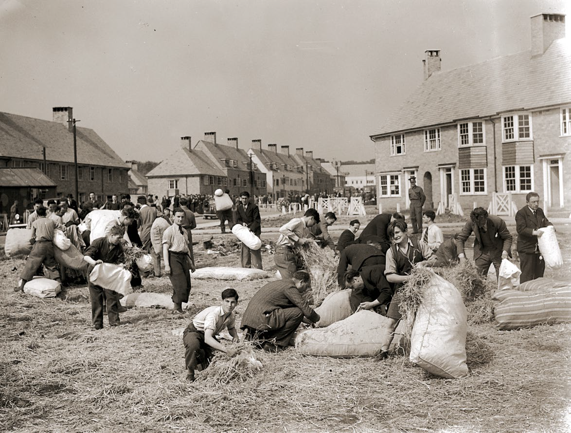 Internowani w brytyjskim obozie napychają worki słomą, na których będą spali, 21 maja 1940 r.