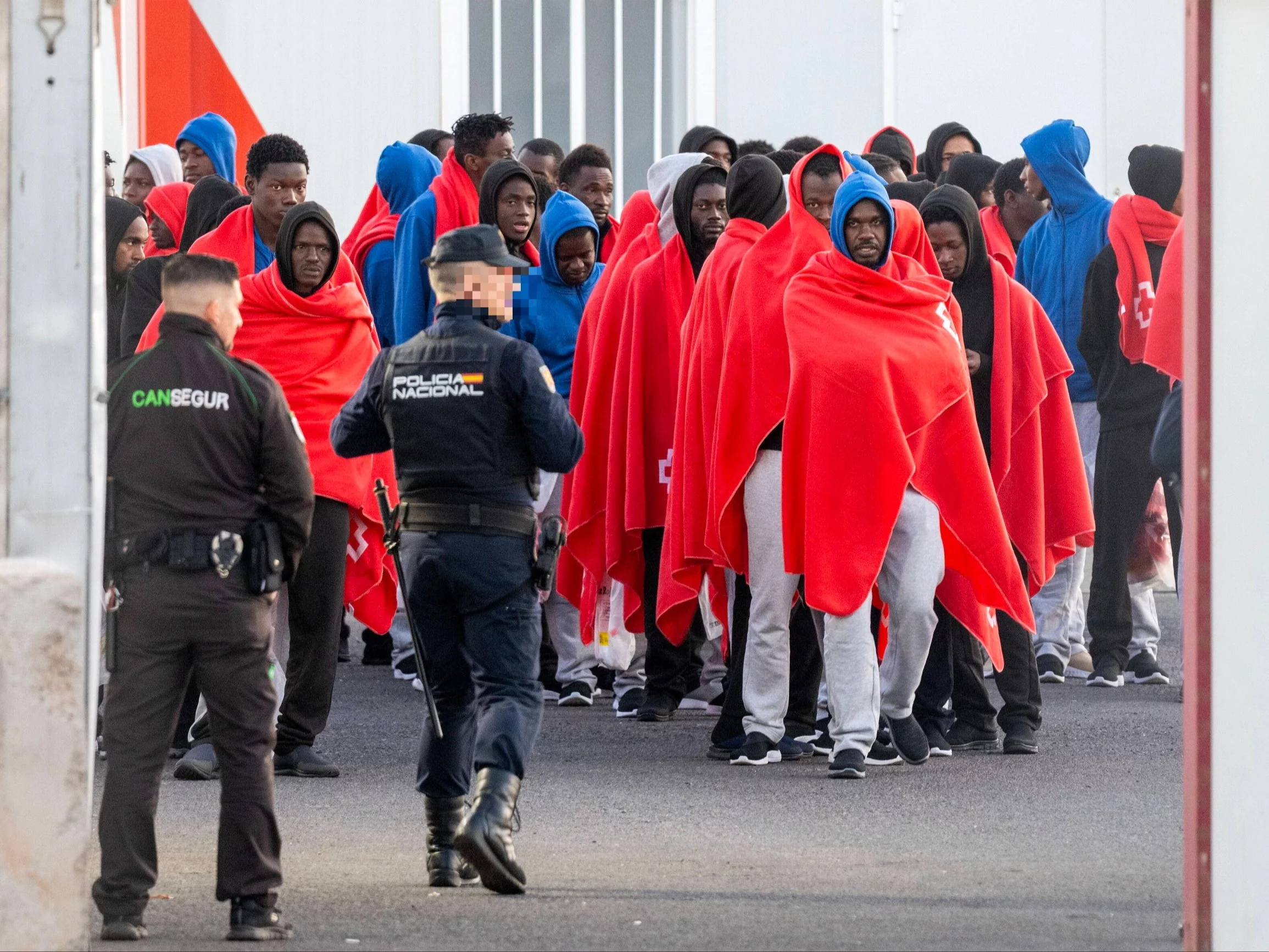 Hiszpańska policja eskortuje migrantów