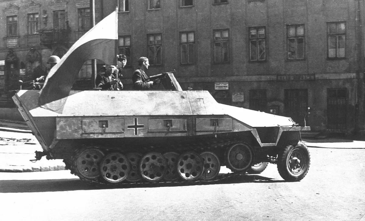 Zdobyty Sd.Kfz. 251 w przelocie na ulicy Tamka. Oficerem z pistoletem MP 40 jest pierwszy dowódca schwytanego pojazdu Adam Dewicz (ps. Szary Wilk). Po jego śmierci transporter został nazwany jego pseudonimem