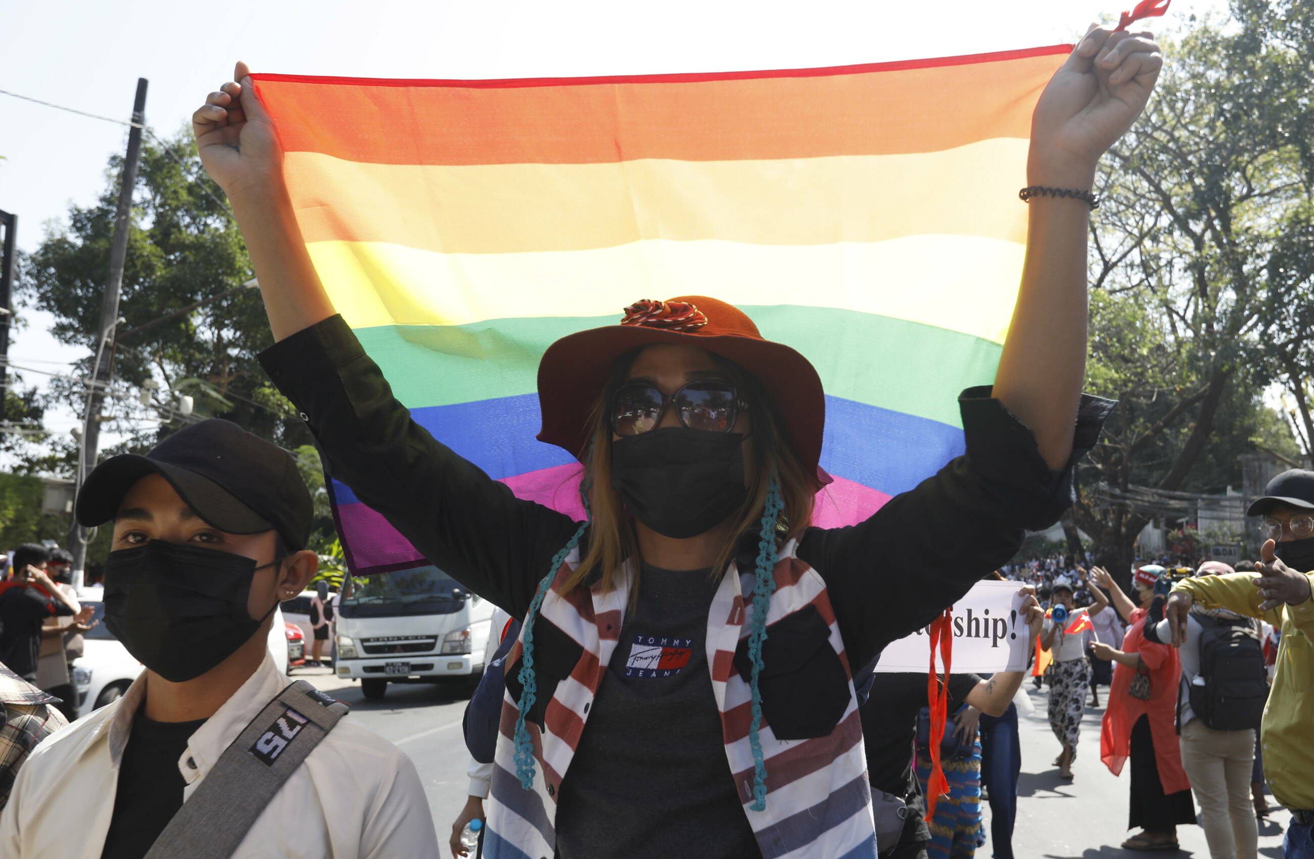 Kobieta trzymająca tęczową flagę, symbolizująca środowiska LGBT