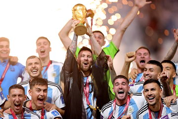 Piłkarze Argentyny wznoszą puchar podczas ceremonii po wygranym finale mistrzostw świata w Katarze.