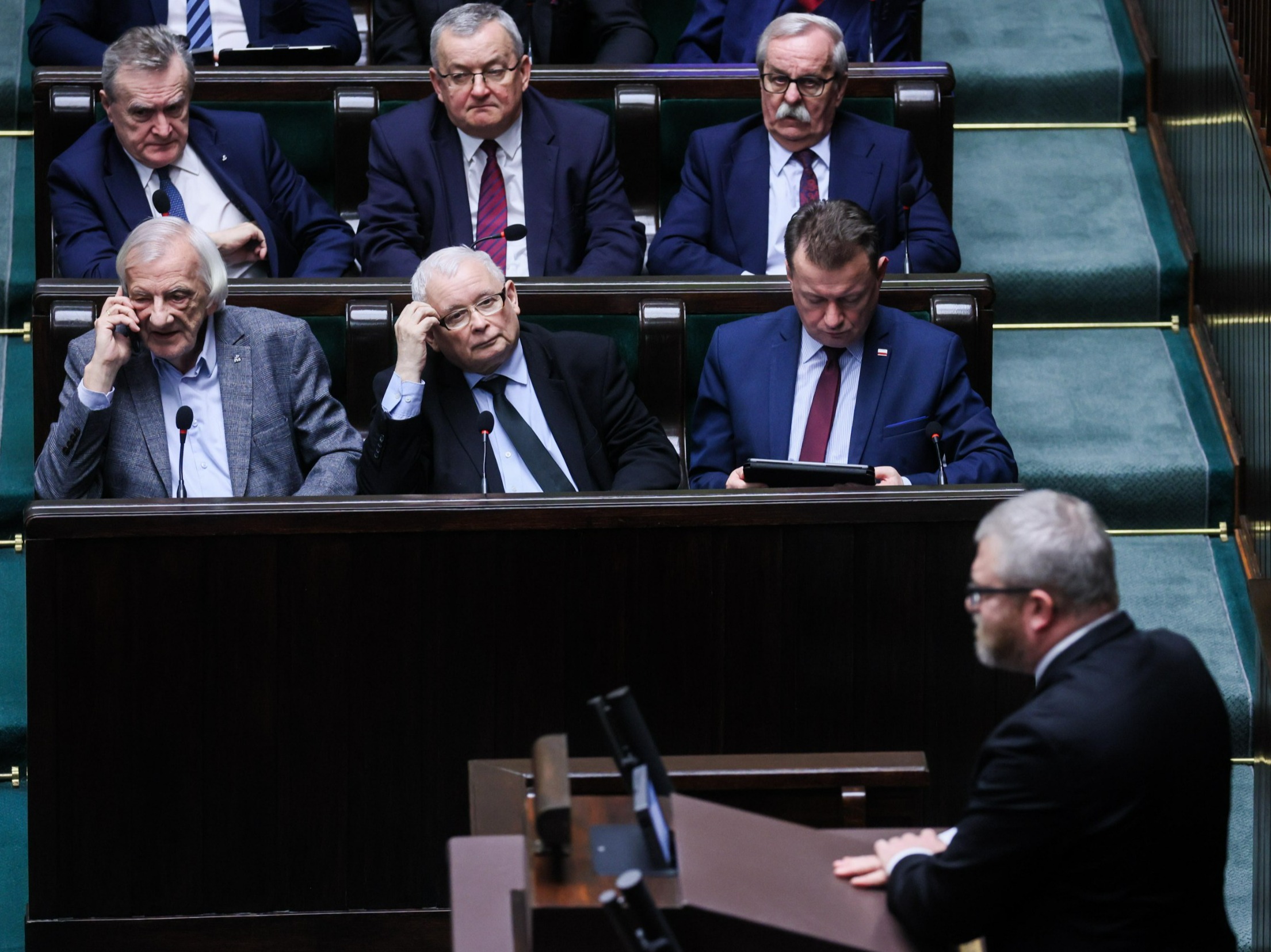 Politycy PiS, od lewej: Ryszard Terlecki, prezes Jarosław Kaczyński, Mariusz Błaszczak; za nimi, od lewej: Piotr Gliński, Andrzej Adamczyk i Leonard Krasulski. Na mównicy: Grzegorz Braun