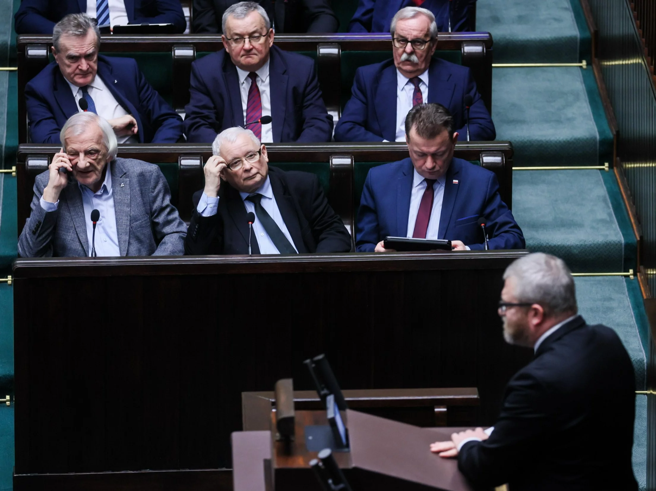 Politycy PiS, od lewej: Ryszard Terlecki, prezes Jarosław Kaczyński, Mariusz Błaszczak; za nimi, od lewej: Piotr Gliński, Andrzej Adamczyk i Leonard Krasulski. Na mównicy: Grzegorz Braun