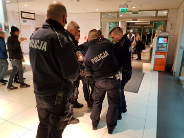 Podejrzany o atak mężczyzna wyprowadzany przez policjantów. W jednej z sal kinowych w centrum handlowym Galaxy w Szczecinie. 26-letni mężczyzna miał zaatakować dwóch innych mężczyzn