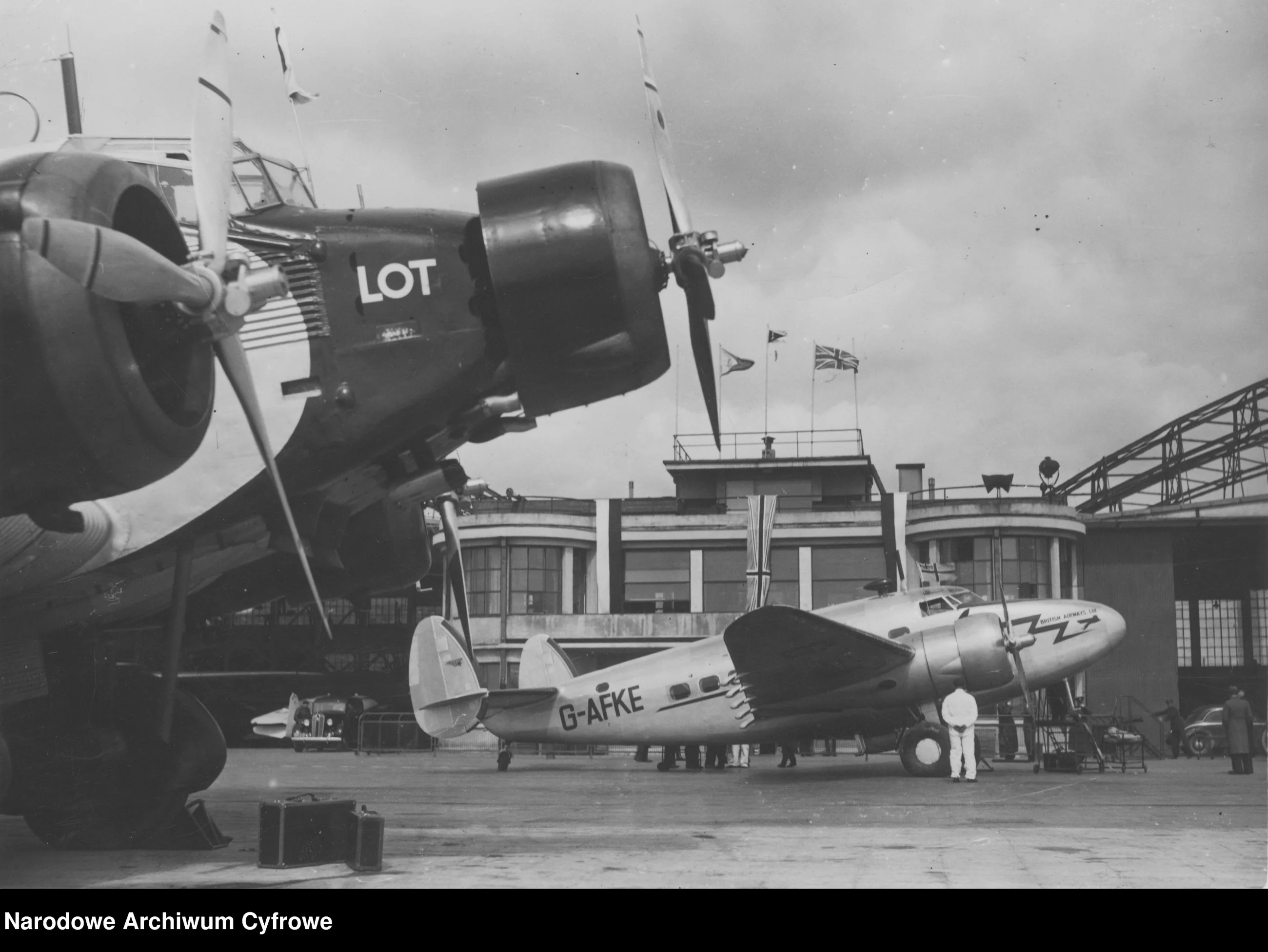 Samolot Lockheed L-14 Super Electra brytyjskich linii lotniczych British Airways po wylądowaniu na lotnisku Okęcie. Widoczny także samolot Junkers Ju-52 należący do PLL LOT