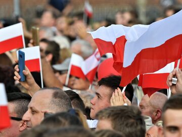 Polacy z biało-czerwonymi flagami, zdjęcie ilustracyjne