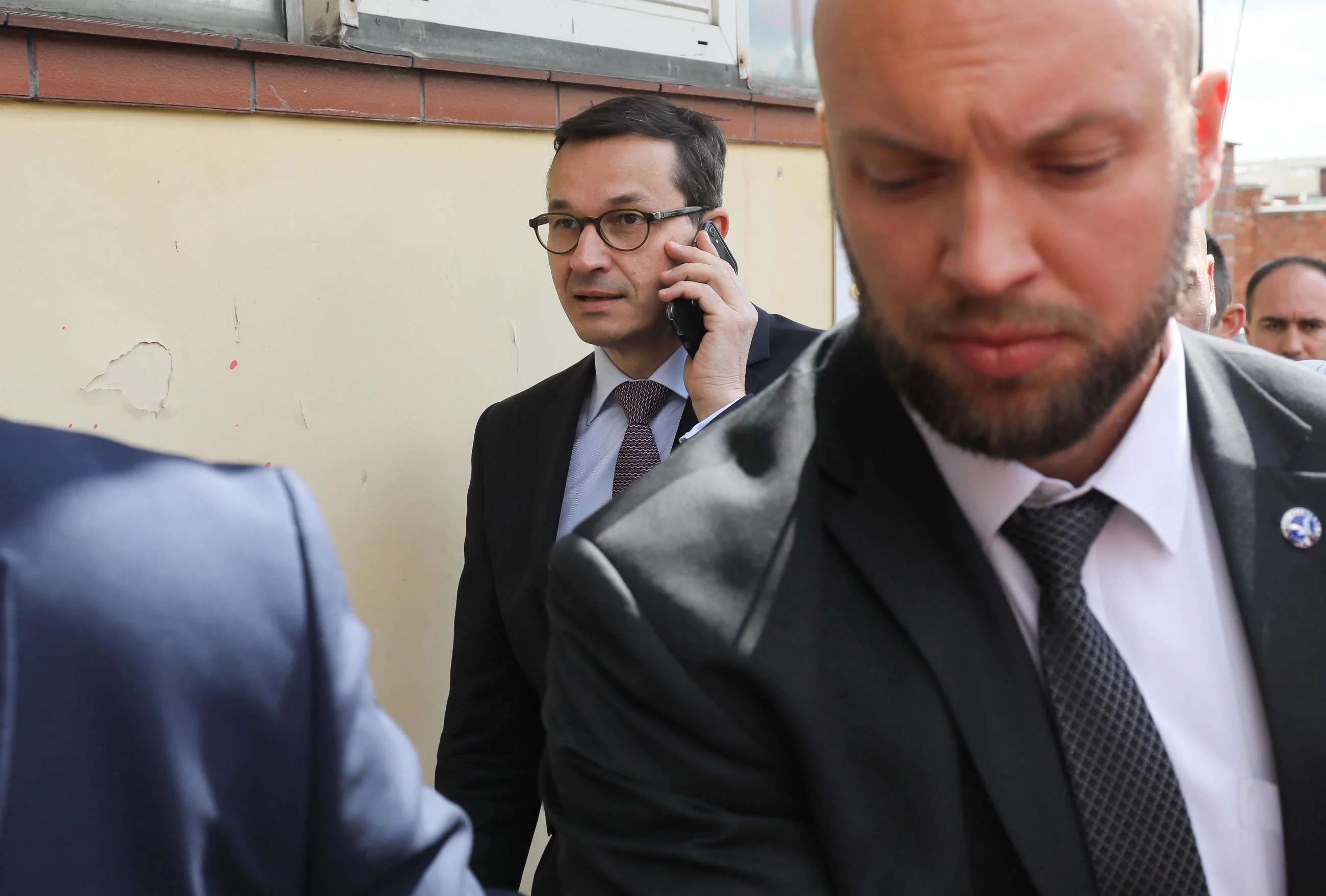 Mateusz Morawiecki rozmawia przez telefon w drodze do siedziby PiS