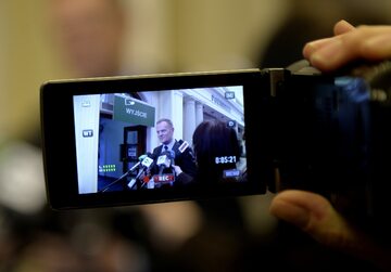 Premier Donald Tusk (na ekranie kamery) rozmawia z dziennikarzami