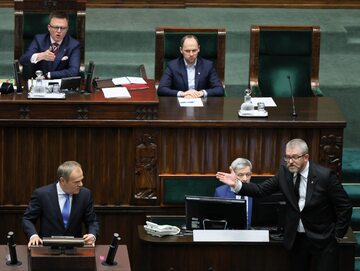 Premier Donald Tusk przemawia na sali obrad Sejmu. Obok poseł Grzegorz Braun (Konfederacja) i marszałek Sejmu Szymon Hołownia