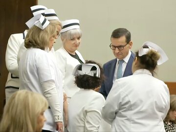 Premier Mateusz Morawiecki podczas rozmowy z pielęgniarkami na galerii w Sejmie