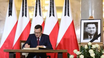 Premier Mateusz Morawiecki wpisuje się do księgi kondolencyjnej wystawionej po śmierci Jana Olszewskiego