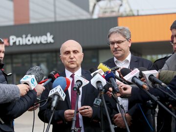 Prezes JSW Tomasz Cudny (z lewej) na tle wejścia do kopalni Pniówek