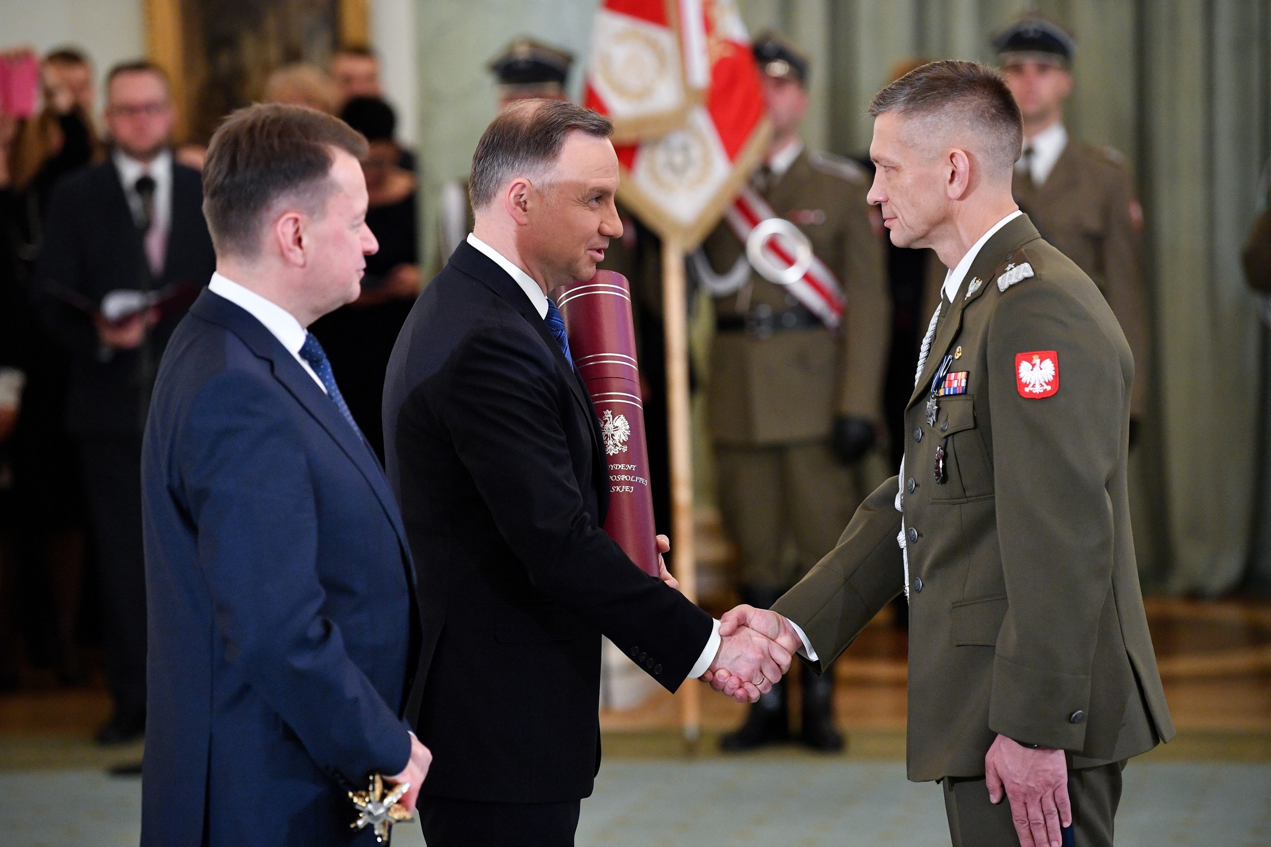 Prezydent Andrzej Duda i szef MON Mariusz Błaszczak oraz nominowany na stopień generała brygady Wojska Polskiego szef Pionu Planowania - zastępca szefa Sztabu Dowództwa Operacyjnego Rodzajów Sił Zbrojnych komandor Adam Rzeczkowski.