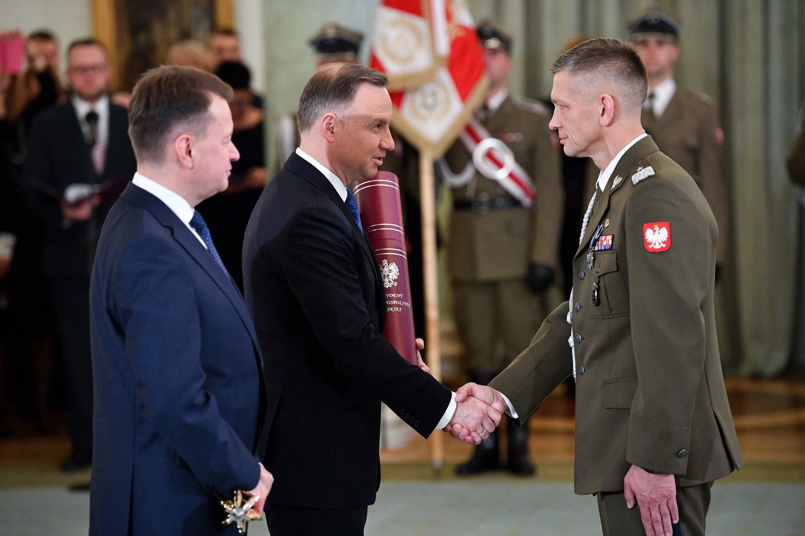 Prezydent Andrzej Duda i szef MON Mariusz Błaszczak oraz nominowany na stopień generała brygady Wojska Polskiego szef Pionu Planowania - zastępca szefa Sztabu Dowództwa Operacyjnego Rodzajów Sił Zbrojnych komandor Adam Rzeczkowski.