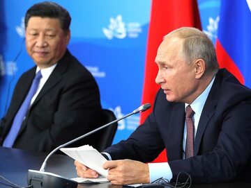 Prezydent Rosji Władimir Putin. W tle przywódca Chin Xi Jinping