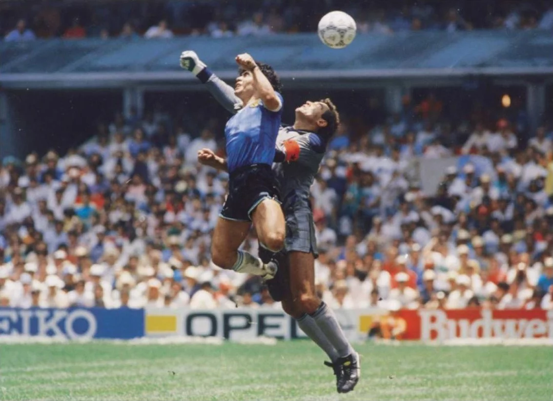 Diego Maradona podczas meczu z Anglią na Mundialu w 1986 roku strzela gol nazwany "ręką Boga"