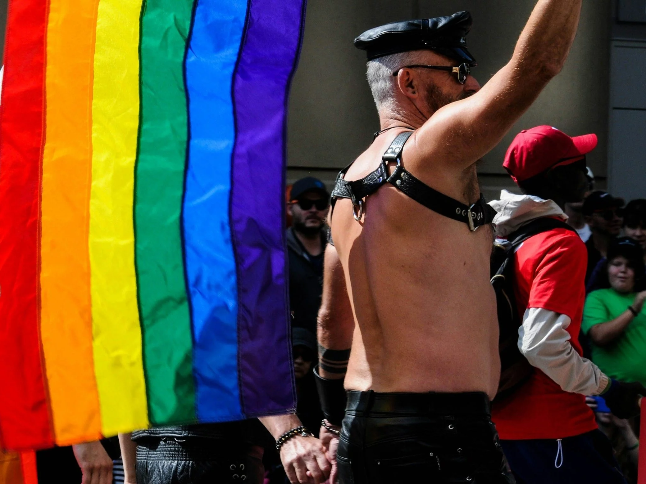 Mężczyzna z flagą LGBT podczas parady. Zdj. ilustracyjne