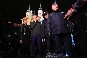 Robert Biedroń i Joanna Scheuring-Wielgus w otoczeniu policjantów przed Katedrą Polową WP