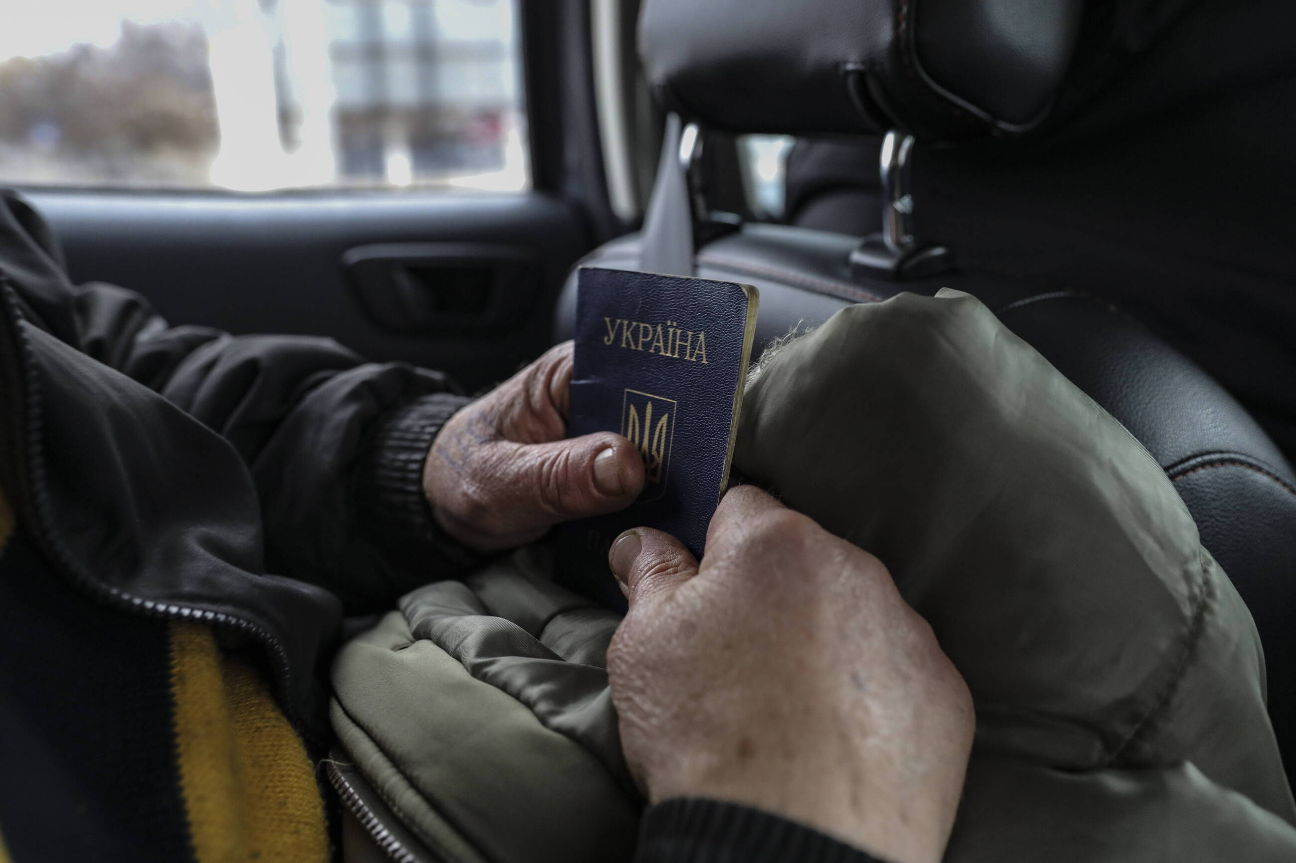 Mężczyzna trzymający w rękach ukraiński paszport.