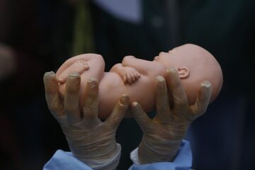 Santiago, Chile. Kobieta trzymająca w dłoniach lalkę przypominającą niemowlę.