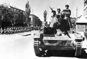Sowiecki czołg T-26 z 6 Dywizji Pancernej przejeżdża przez irańskie miasto Tabriz. W tle oddział piechoty Armii Czerwonej