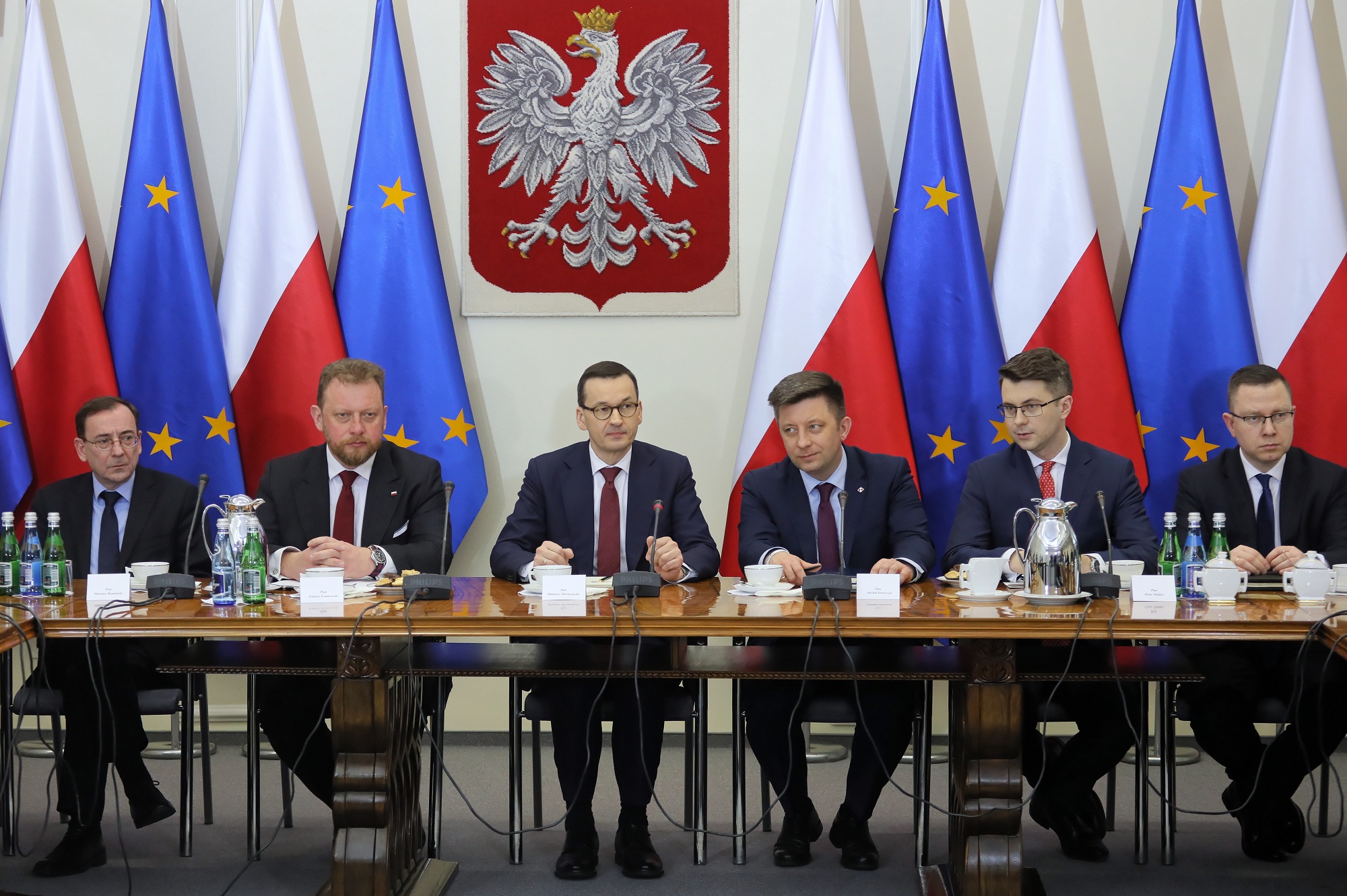 Premier RP Mateusz Morawiecki (3L), minister spraw wewnętrznych i administracji Mariusz Kamiński (L), minister zdrowia Łukasz Szumowski (2L), szef KPRM Michał Dworczyk (3P), rzecznik rządu Piotr Mueller (2P) podczas spotkania z przedstawicielami klubów i