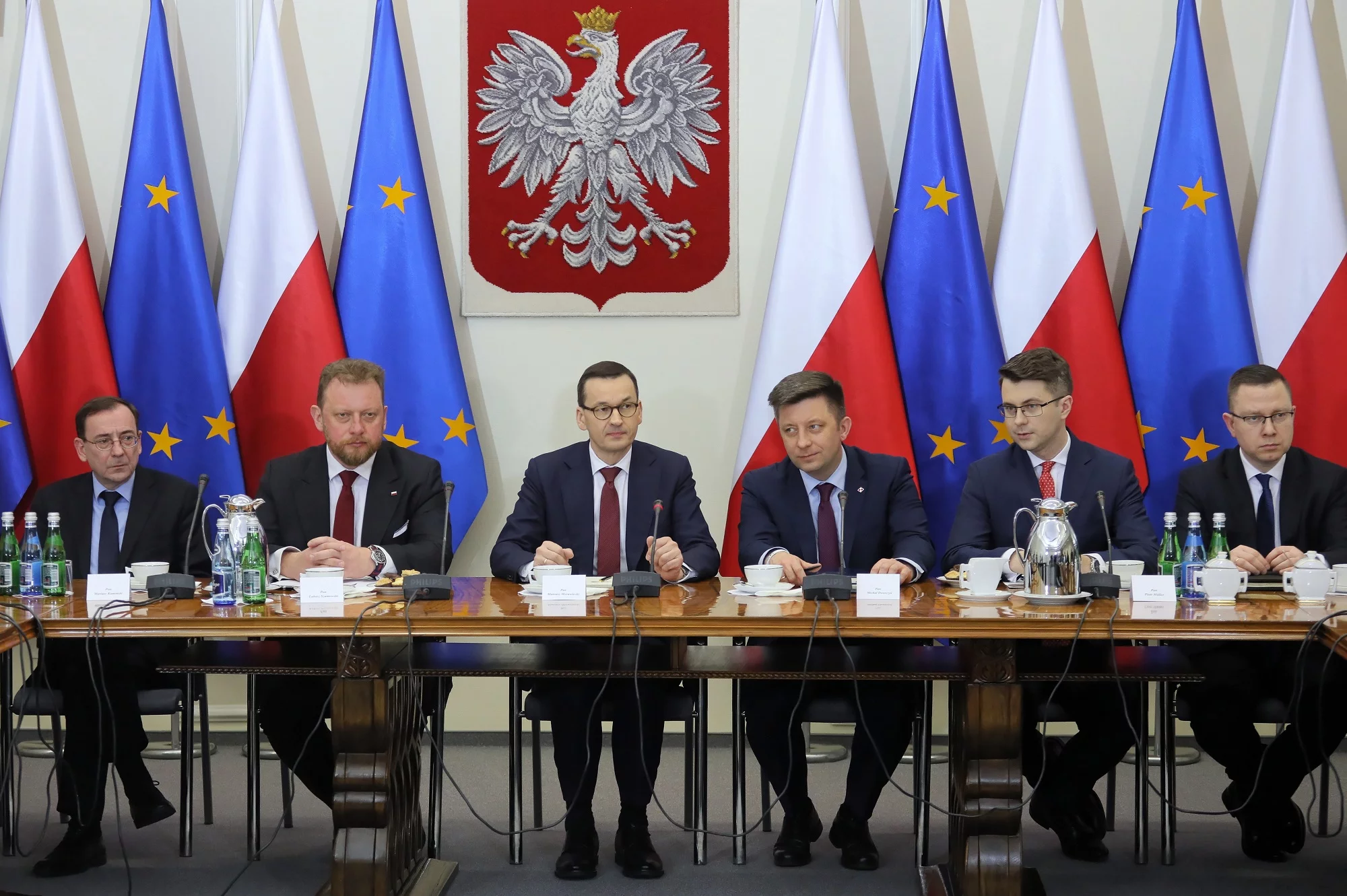 Premier RP Mateusz Morawiecki (3L), minister spraw wewnętrznych i administracji Mariusz Kamiński (L), minister zdrowia Łukasz Szumowski (2L), szef KPRM Michał Dworczyk (3P), rzecznik rządu Piotr Mueller (2P) podczas spotkania z przedstawicielami klubów i