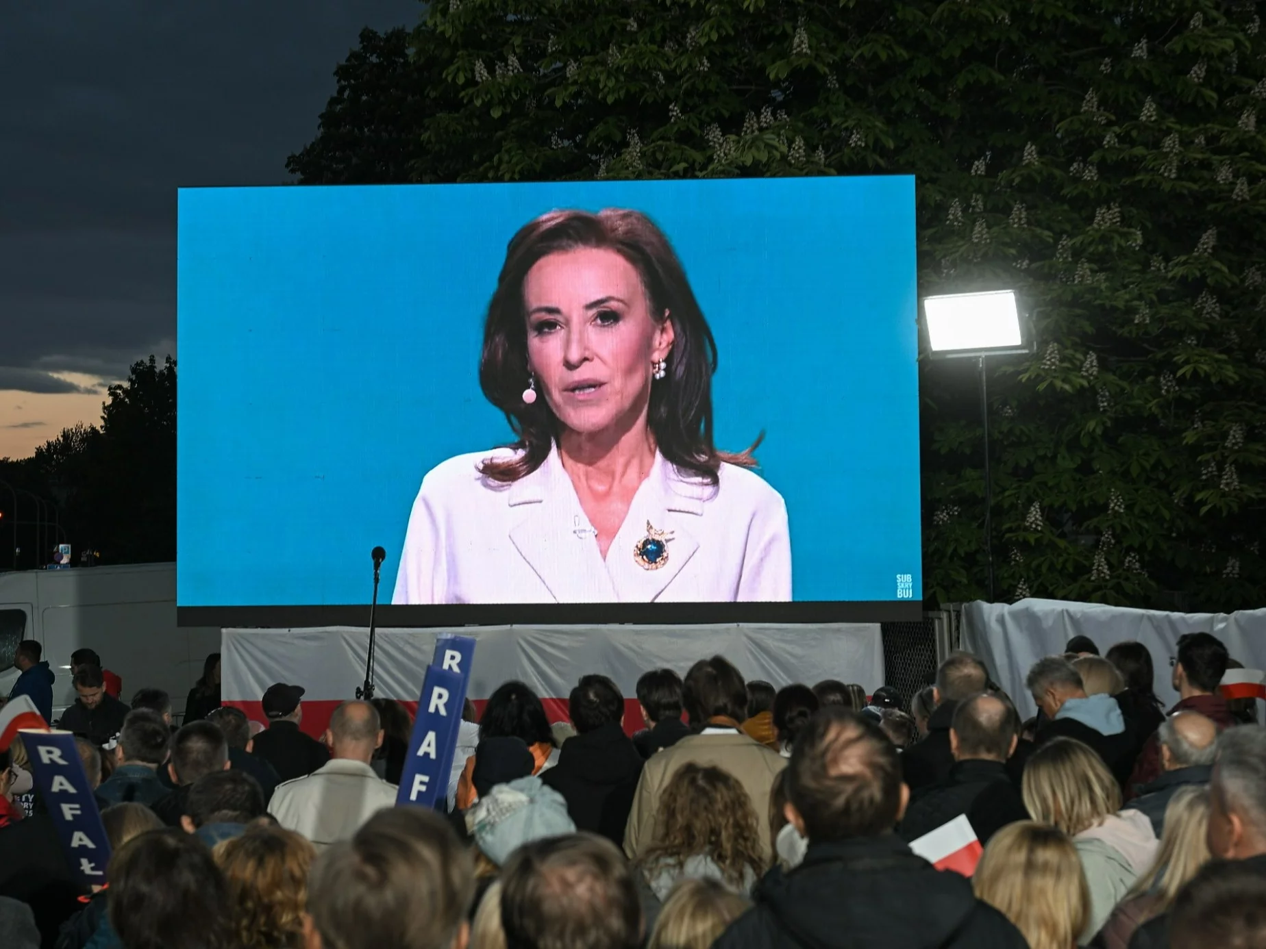 Wybory Prezydenta RP 2025 - kampania. Dziennikarka Dorota Wysocka-Schnepf (na telebimie) przed gmachem TVP w Warszawie