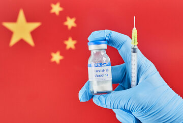 Szczepionka przeciw COVID-19 na tle chińskiej flagi, zdjęcie ilustracyjne