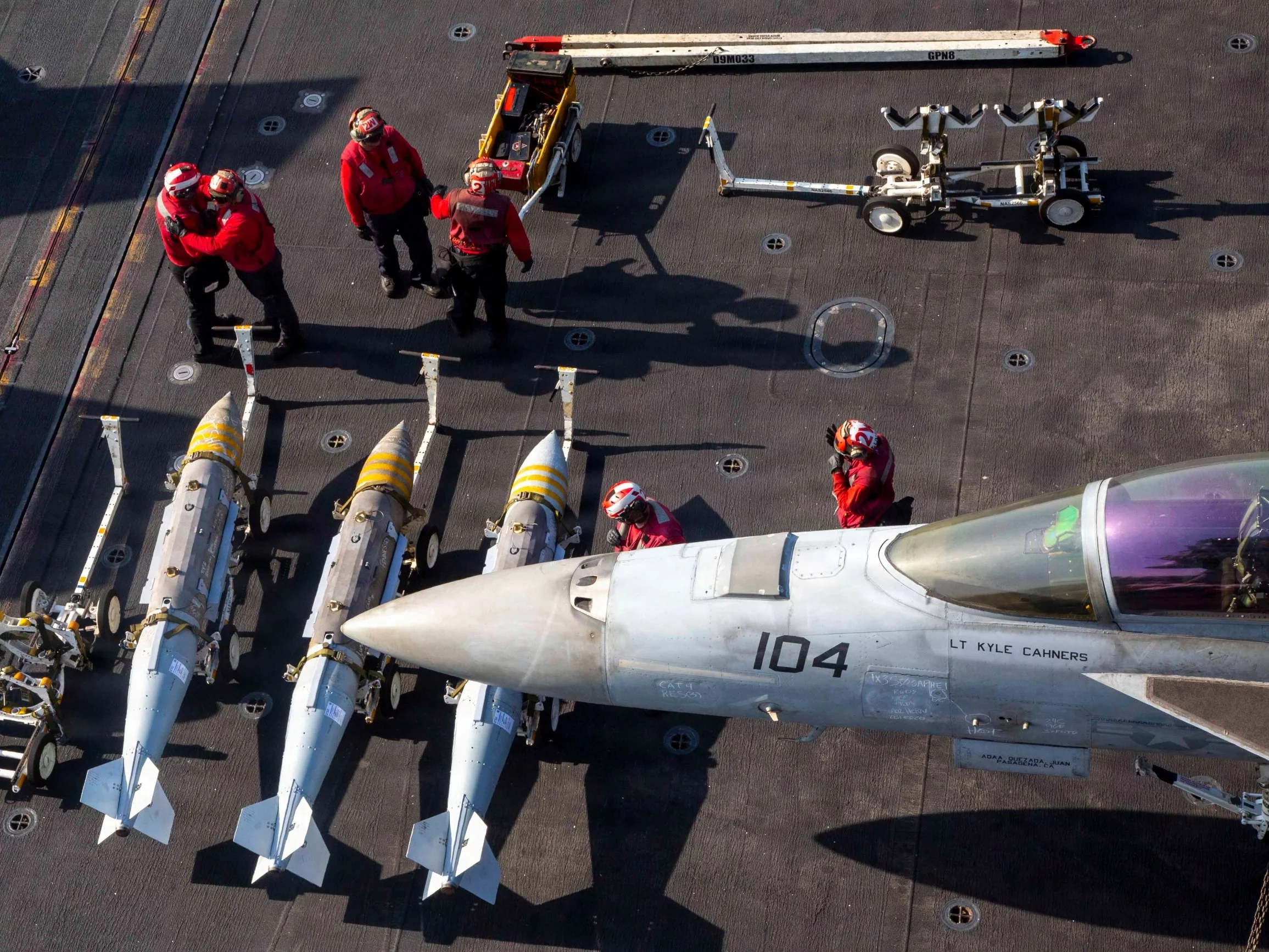 Amerykańscy marynarze przygotowują się do załadunku amunicji na samolot F/A-18F Super Hornet na pokładzie lotniskowca USS Abraham Lincoln