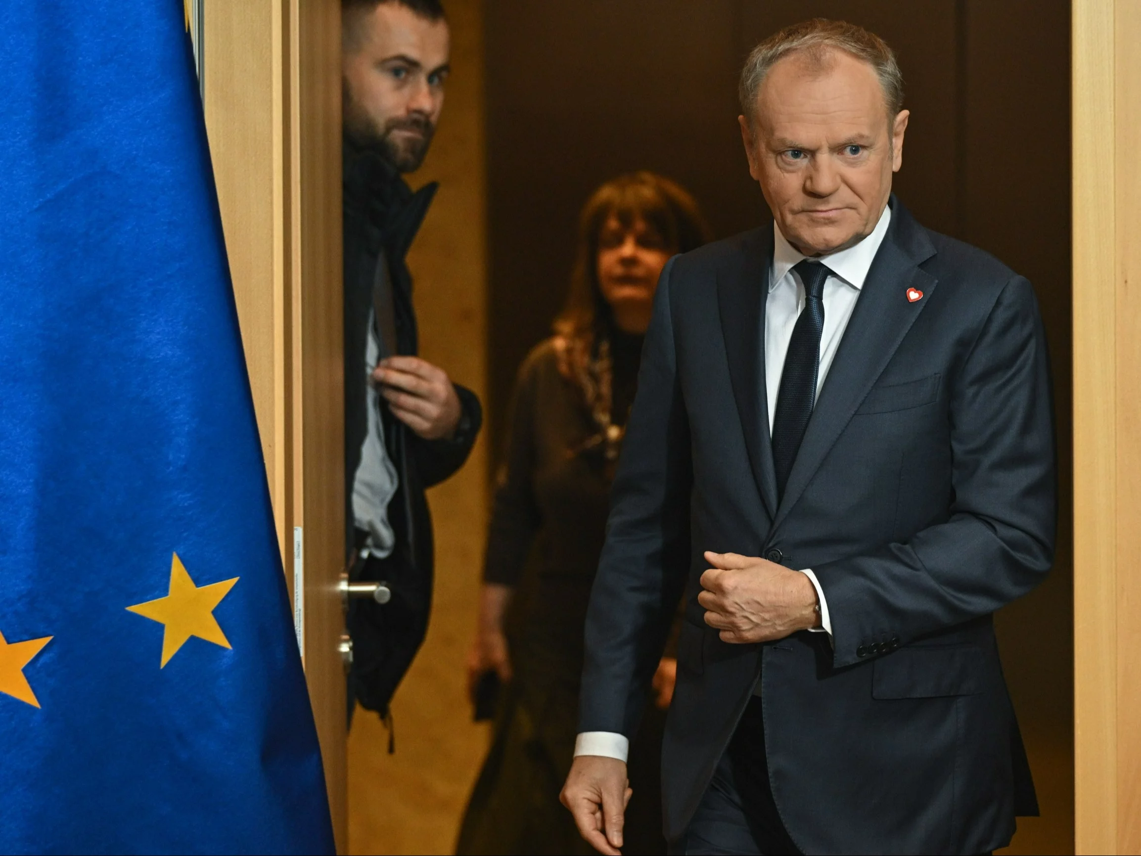 Premier Donald Tusk (P) w drodze na konferencję prasową na lotnisku w Warszawie