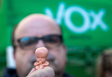 Uczestnik demonstracji przeciwko aborcji trzyma miniaturową zabawkę imitującą ludzki płód.
