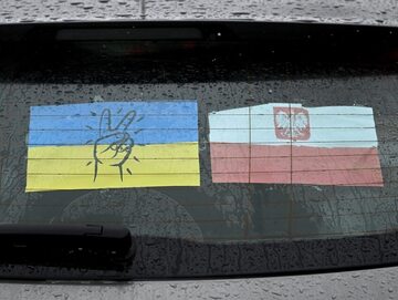 Ukraińska i polska flaga na szybie samochodu przy Centrum Pomocy Humanitarnej w Przemyślu
