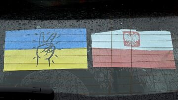 Ukraińska i polska flaga na szybie samochodu przy Centrum Pomocy Humanitarnej w Przemyślu