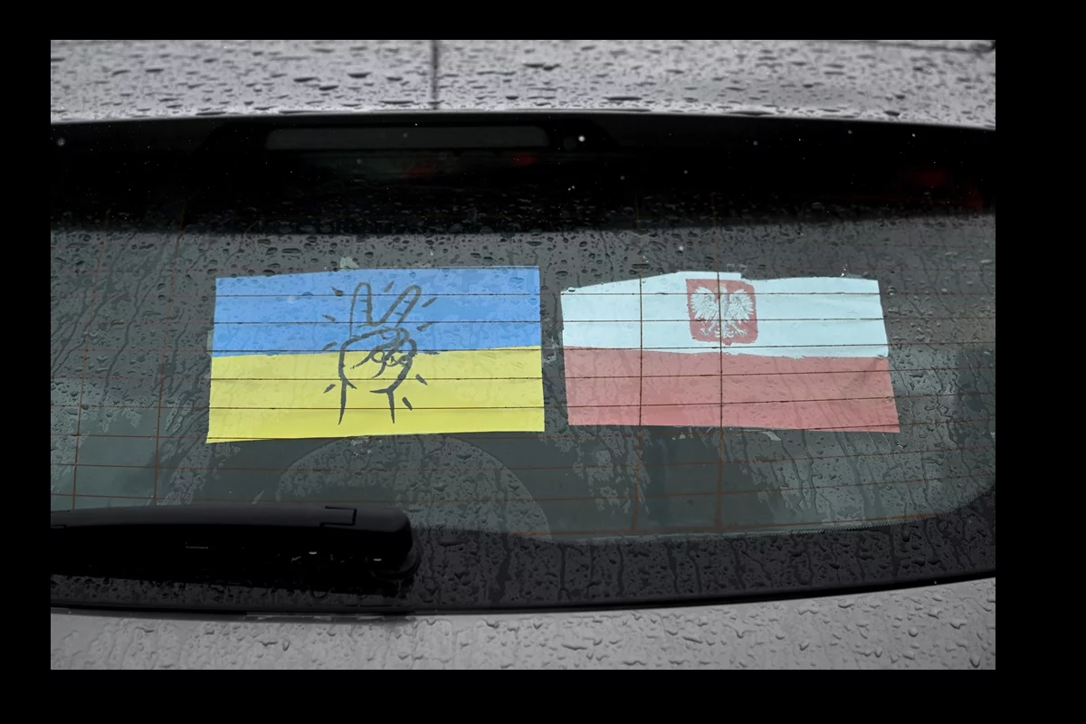 Ukraińska i polska flaga na szybie samochodu przy Centrum Pomocy Humanitarnej w Przemyślu