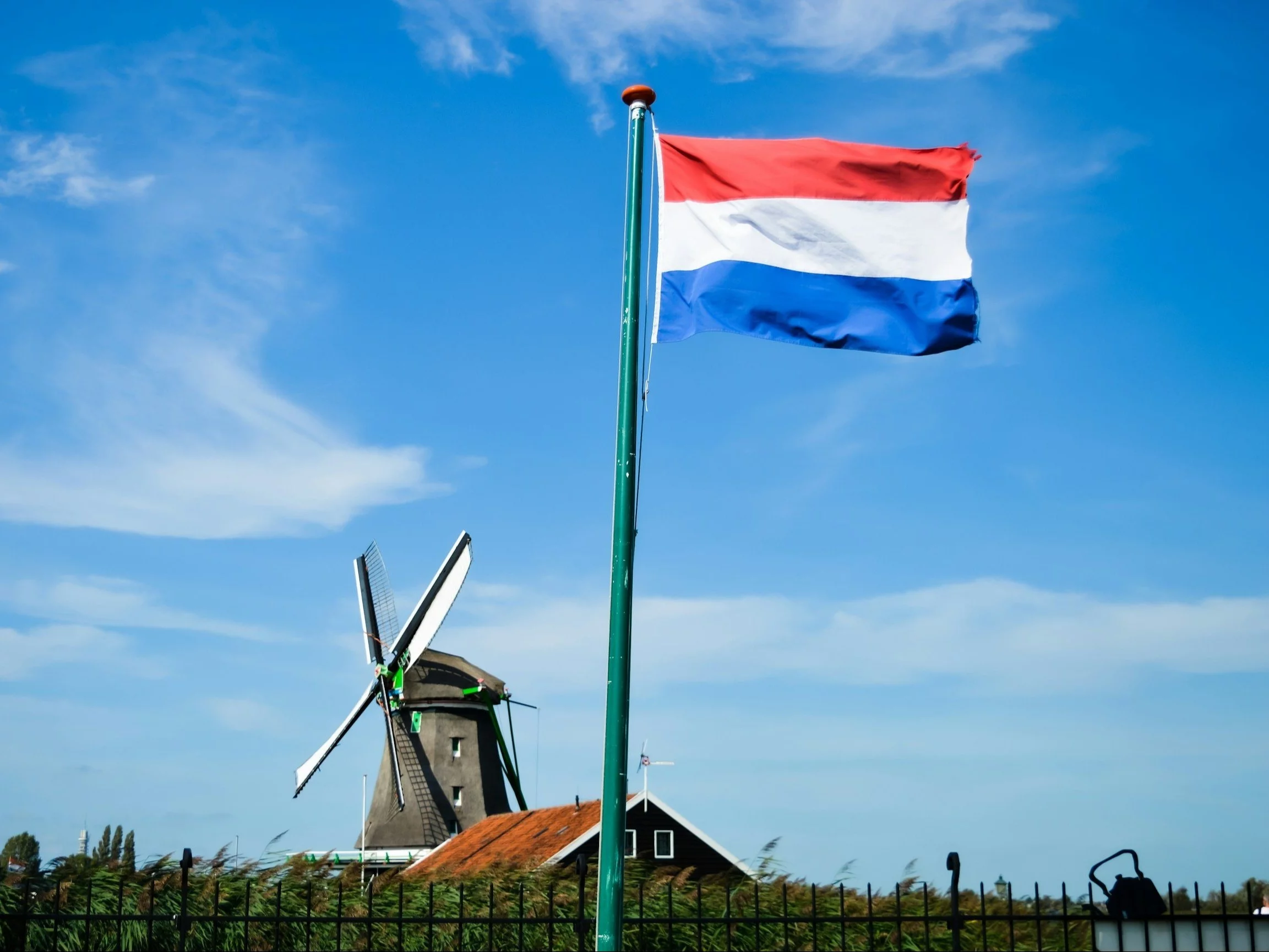 Netherlands flag-waving close in Zaanse Schans, one of the Netherlands postcards due to the historical windmills