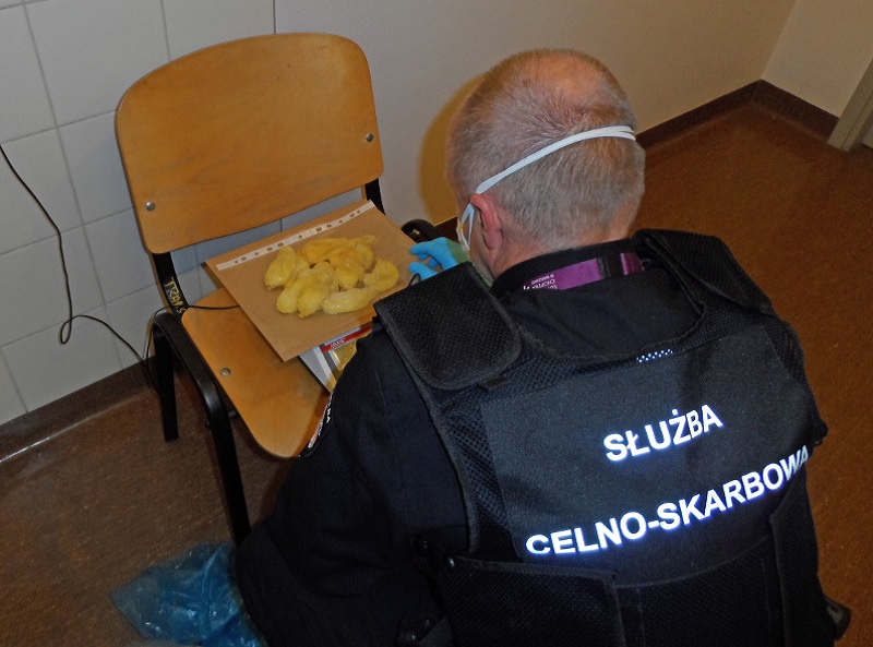 Funkcjonariusz waży pierwszą partię woreczków gumowych z narkotykami