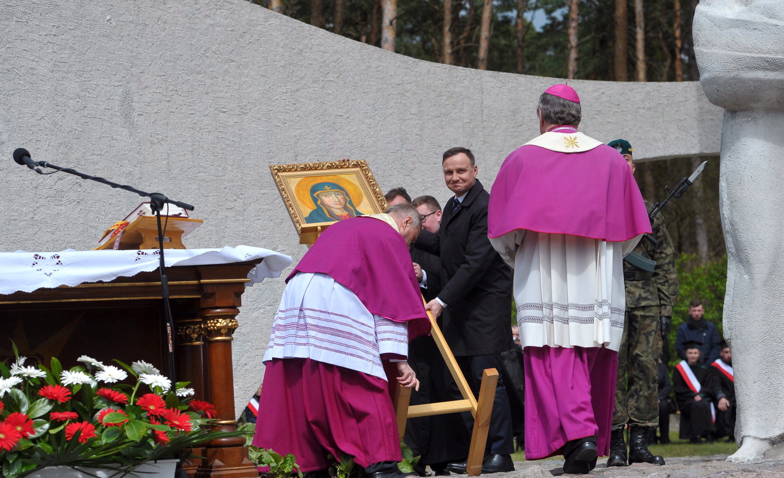 Prezydent Andrzej Duda (C) pomógł podnieść obraz, który przewrócił się przez silny wiatr, podczas obchodów 72. rocznicy forsowania Odry przez 1. Armię Wojska Polskiego