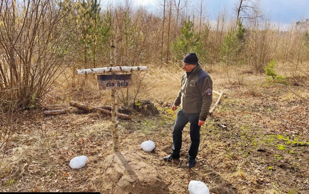 Dariusz Szymanowski ze Stowarzyszenia "Wizna" przy zrekonstruowanym pierwszym grobie "Hubala"
