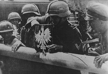 Wrzesień 1939 r. Żołnierze niemieccy niszczą szlaban graniczny i godło Polski