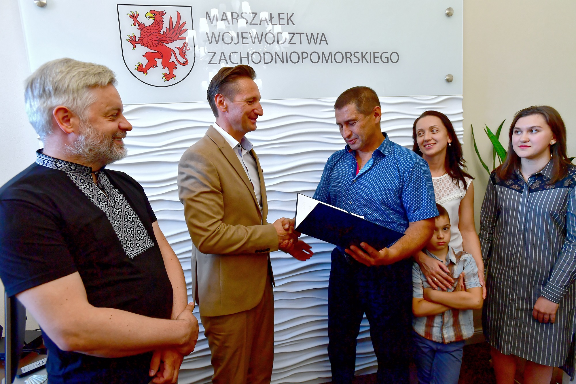 Marszałek województwa zachodniopomorskiego Olgierd Geblewicz oraz pan Andrij z żoną i dziećmi podczas spotkania w Szczecinie. Kierowca z Ukrainy uratował kilka osób, z płonących aut po wypadku na A6 pod Szczecinem.