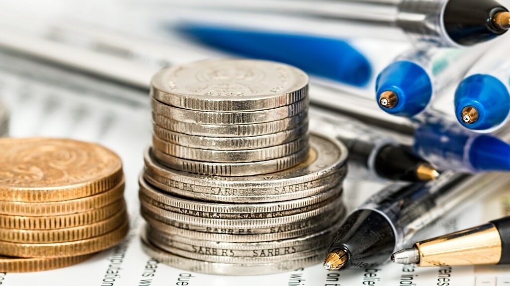 Długopisy i monety. Zdjęcie ilustracyjne