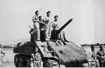 Żołnierze 2 Korpusu Polskiego po bitwie o Bolonię – generałowie Władysław Anders (1. z prawej) i Bronisław Rakowski (2. z prawej) na wieży czołgu M4 Sherman